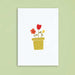 white greeting card with no text and drawing of plant pot with 2 red flowers and 1 yellow flower in it card is against a green background