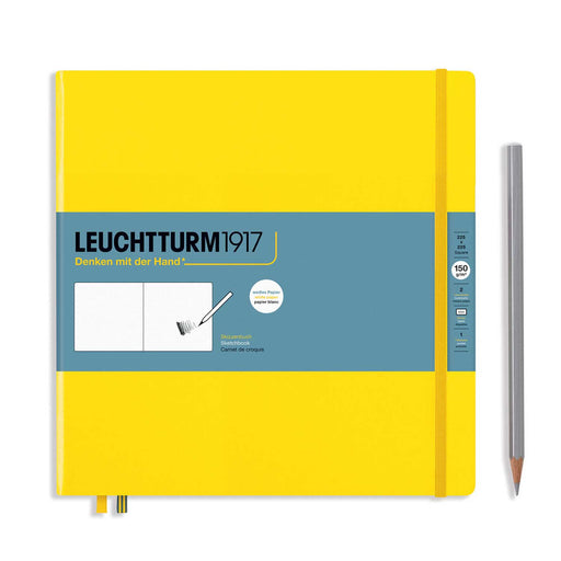 square yellow Leuchtturm1917 sketchbook with blue paper band across cover, yellow elstic and silver pencil to right. Against a white background