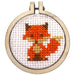 Cross-stitched fox design in a wooden hoop on a white background