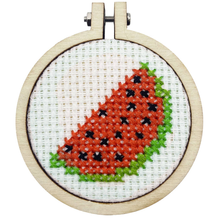 Cross-stitched watermelon design in a wooden hoop on a white background