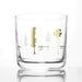glass whiskey tumbler with tree silhouette in gold foil around outside of glass