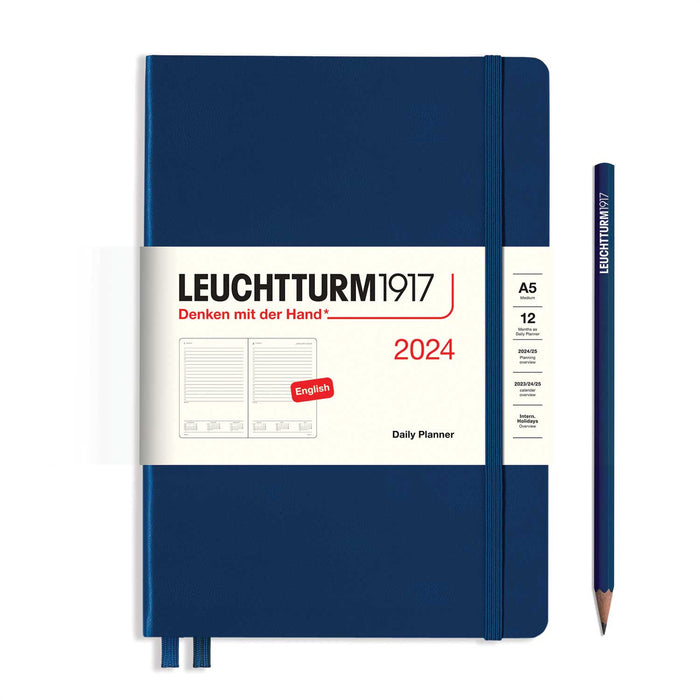 blue 2024 leuchtturm1917 daily planner with white paper banc, two blue ribbon page markers blue elastic band and pencil to right