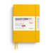 A yellow Leuchtturm1917 2027 daily planner with a white paper sleeve label, shown on a clean white background.