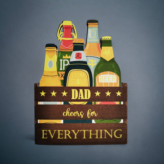 Decorative sign with beer bottles and 'Dad, cheers for everything' text on a gray background