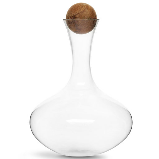 Clear glass decanter with a bulbous base and narrow neck, topped with a round natural wood stopper, isolated on a white background.