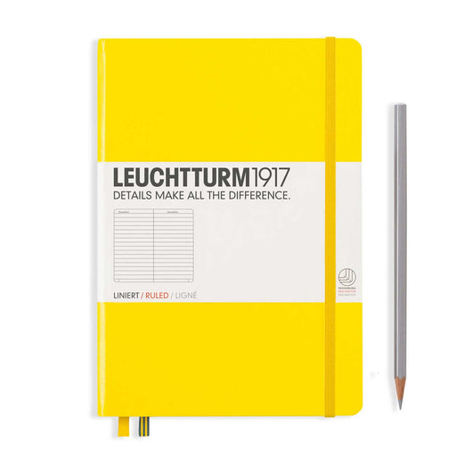 A5 yellow cover notebook with 2 ribbon bookmarks and yellow elastic closure. Silver pencil to the right