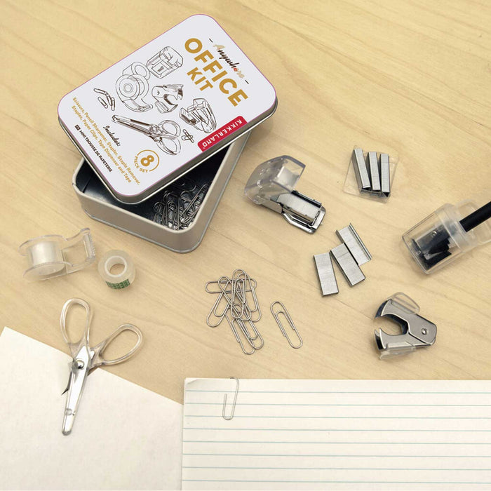 office kit white tin with scissors, cellotape holder and tape, paperclips staples and black pencil in a pairer all on a brown tabletop