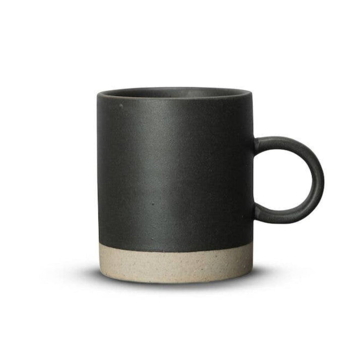 A matte black ceramic mug with a contrasting light beige textured band at the base and a matching black loop handle, shown on a plain white background.