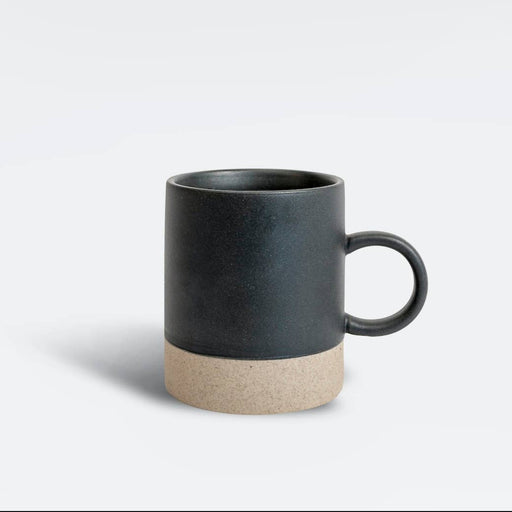 A ceramic mug with a matte black upper body and handle, and a textured beige lower band, shown on a clean light gray background.