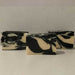 3 bars of black and white swirl patterned soap in 
front of a grey background