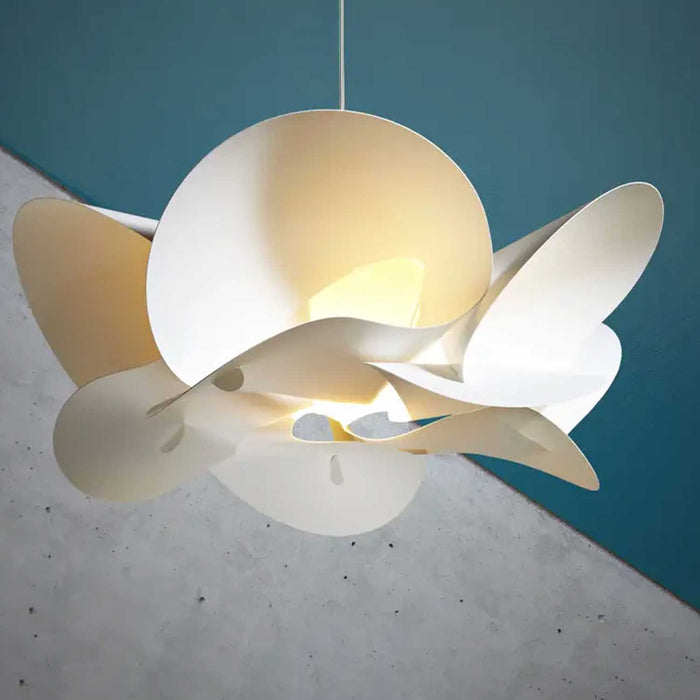 cream white abstract floral bloom shaped light shade hanging from a white wire against a blue and concrete grey background