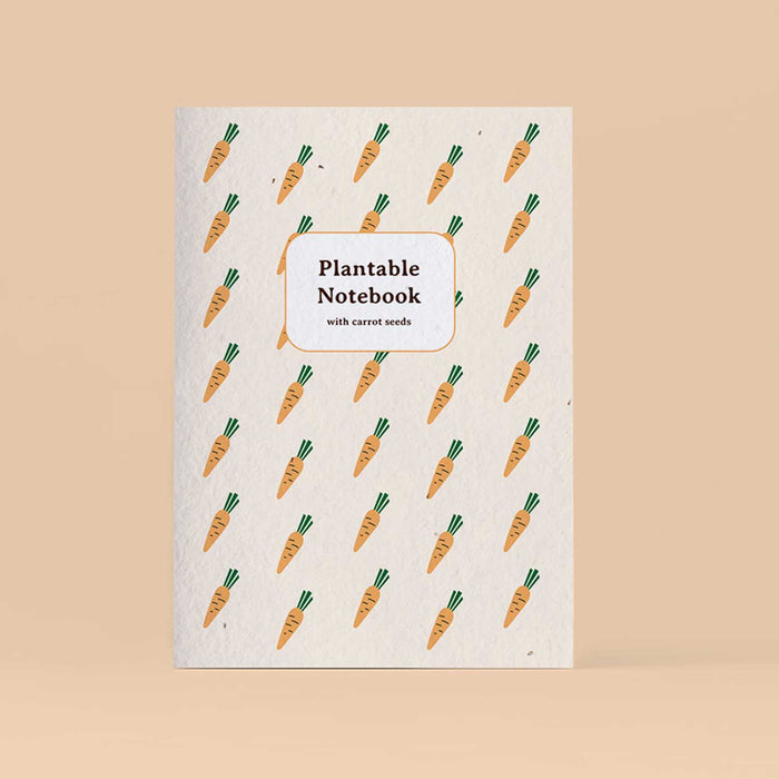 Plantable notebook with orange and green carrot pattern on a pink backdrop