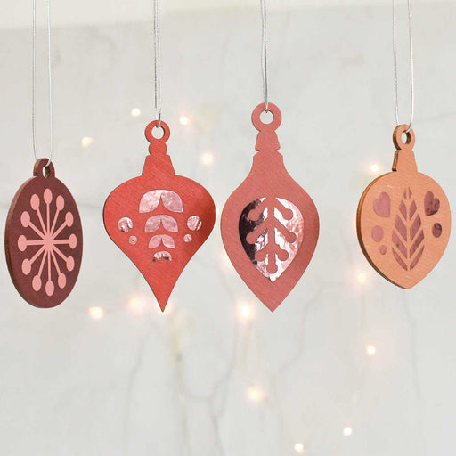 four flat wooden red hanging decorations on looped string with copper printed patterns