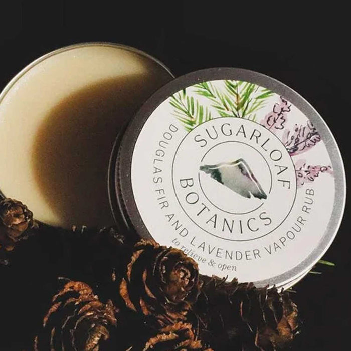 Open Sugarloaf Botanics round metal tin with white sticker on lid. Tin contains solid wax vapour rub. 