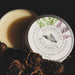 Open Sugarloaf Botanics round metal tin with white sticker on lid. Tin contains solid wax vapour rub. 