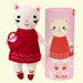 Stuffed cat toy in a red dress with a matching tube packaging on a white background