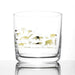 whiskey glass with two rows of golden dinosaurs, mammoths and man on the outside