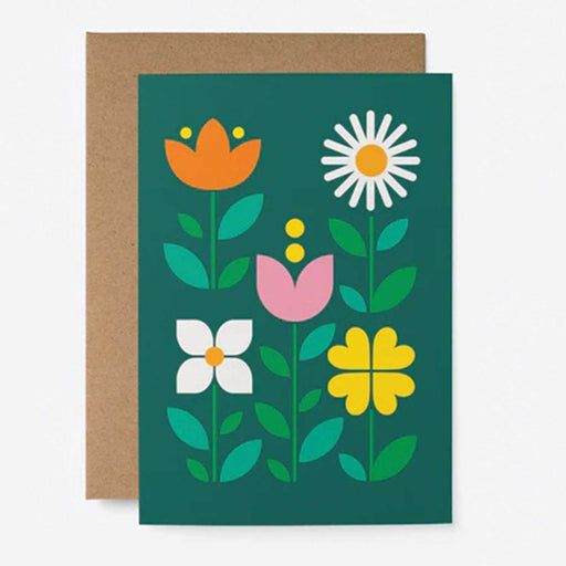 green greeting card with 5 graphic flowers on front, one with one orange one pink one yellow and on white daisy with brown envelop behind