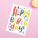 white textured card with Happy Birthday in bright multi coloured text on front on pink background
