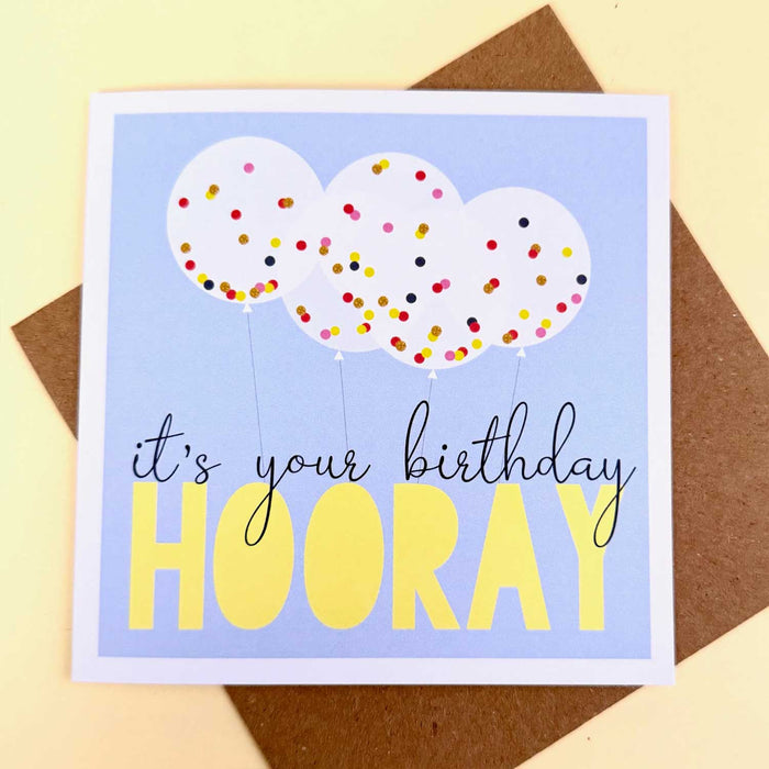 blue square birthday card with white  border and five clear balloons with speckled colourful confetti inside
