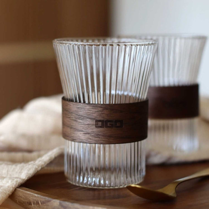two ridged clear glass cups with wooden bands around centre