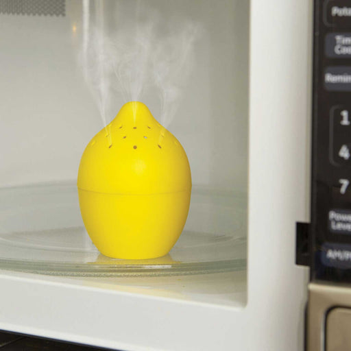 lemon shaped kitchen tool with holes in top sitting in an open microwave, emitting steam from the holes