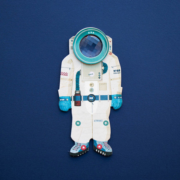 Cardboard cutout of an astronaut suit with a kaleidoscopic window in the helmet on a blue background