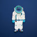 Cardboard cutout of an astronaut suit with a kaleidoscopic window in the helmet on a blue background