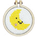 Cross-stitched yellow moon in a wooden hoop on a white background