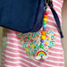 COLOURFUL ELEVEN BEAD KEYRING WITH RAINBOW BEAD ON END, HANGING OFF A CHILDS BAG