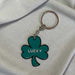 green shamrock keyring with  black outline and lucky in white text in centre