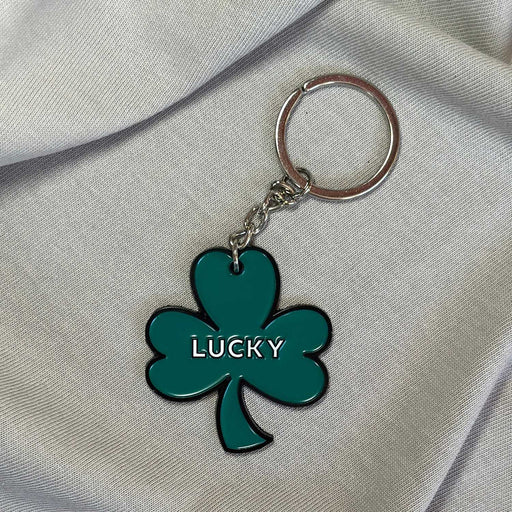green shamrock keyring with  black outline and lucky in white text in centre