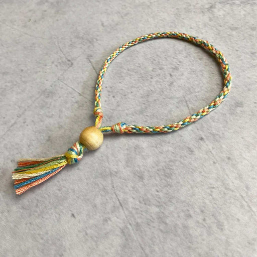 coloured thin woven thread bracelet with wooden bead and knotted end