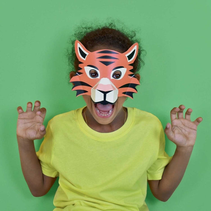 child in green tshirt wearing a tiger mask and roaring with hands up