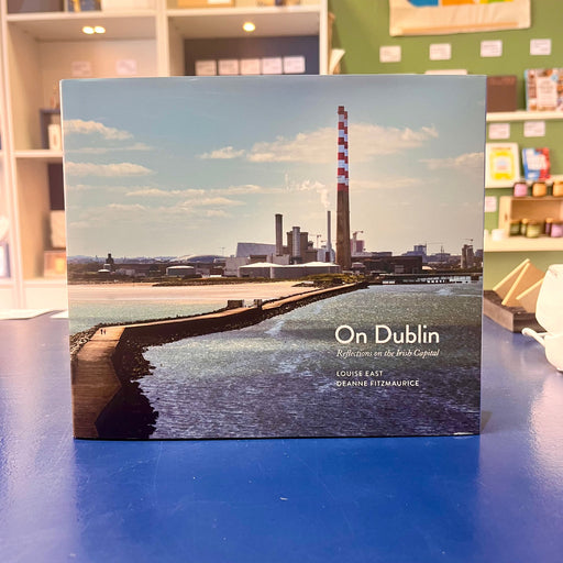 Book titled 'On Dublin' with a cityscape on the cover, placed on a blue surface with shop background.