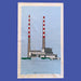 blue tea towel with white boarder and print of a low grey building with two red and white striped long chimney towers