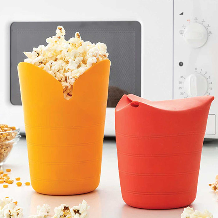 Popbox Collapsible Popcorn Maker containers one yellow open and full of popcorn, and one red closed both in front of a white microwave