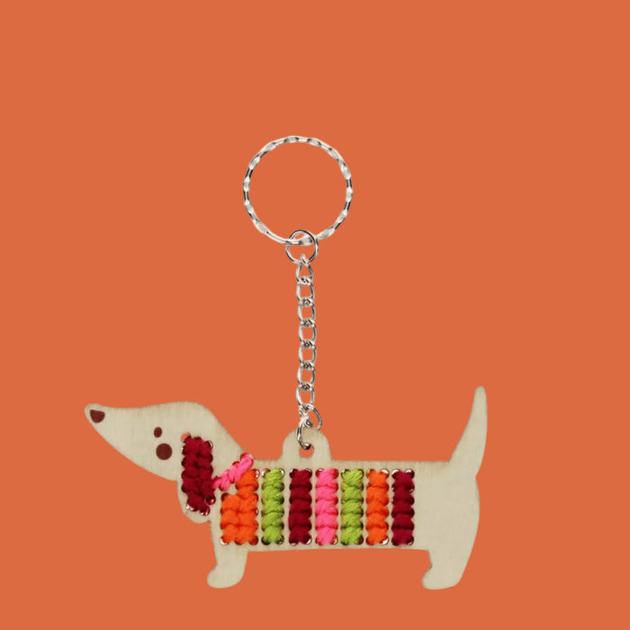 Keychain in the shape of a dachshund with a colorful striped pattern on a white background
