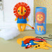 Colorful lion plush toy with sewing kit components on a table