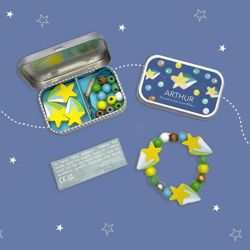 TWO SMALLMETAL TINS, ONE OPEN WITH COLOURFUL BEADS INSIDE AND STAR BRACLET TO LOWER RGHT
