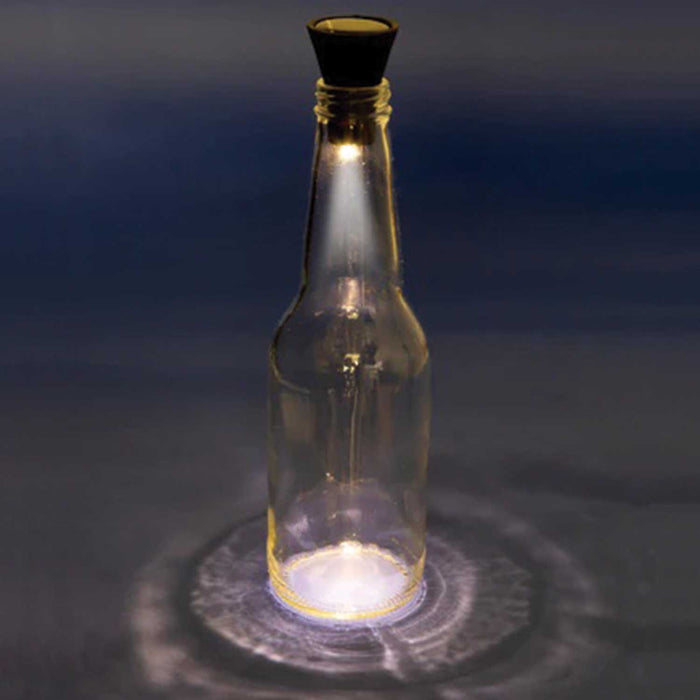 black solar powered cork light sitting on the oopening of a clear glass bottle