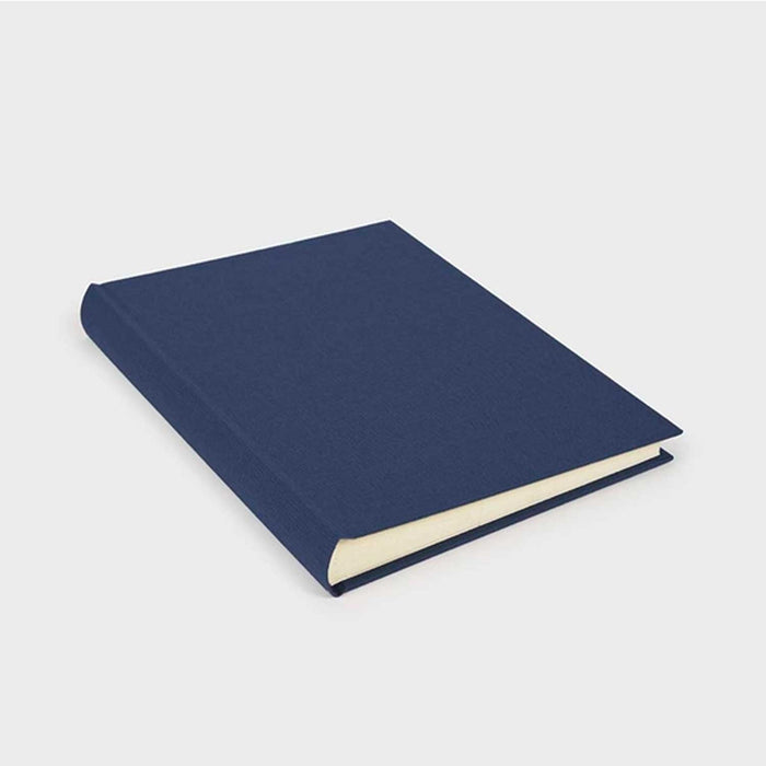 Blue fabric covered photo album  with an ivory interior on a light grey background