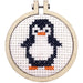 Cross-stitched penguin in a wooden hoop on a white background