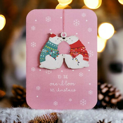 pink greeting card with ornament of two polar bears in xmas jumpers touching noses