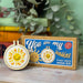 Cross stitch mini kit with 'You are my sunshine' design on a wooden surface with a plant in the background.