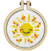 Cross-stitched smiley face design in a wooden hoop on a white background
