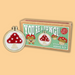 Cross-stitch mini kit with mushroom design and packaging labeled 'You're a Fungi!' on a beige background.