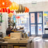 interior of designist shop facing door. colourful lampshades in the foreground