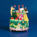 Colorful 3D pop-up kids' birthday card on an animal-themed cake, on a blue background