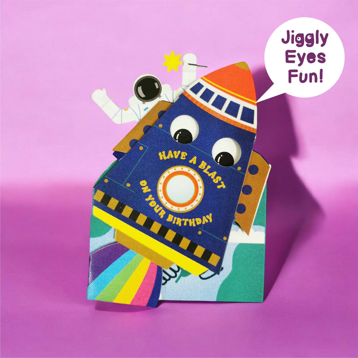 Colourful birthday card with a rocket with jiggly eyes on a pink background